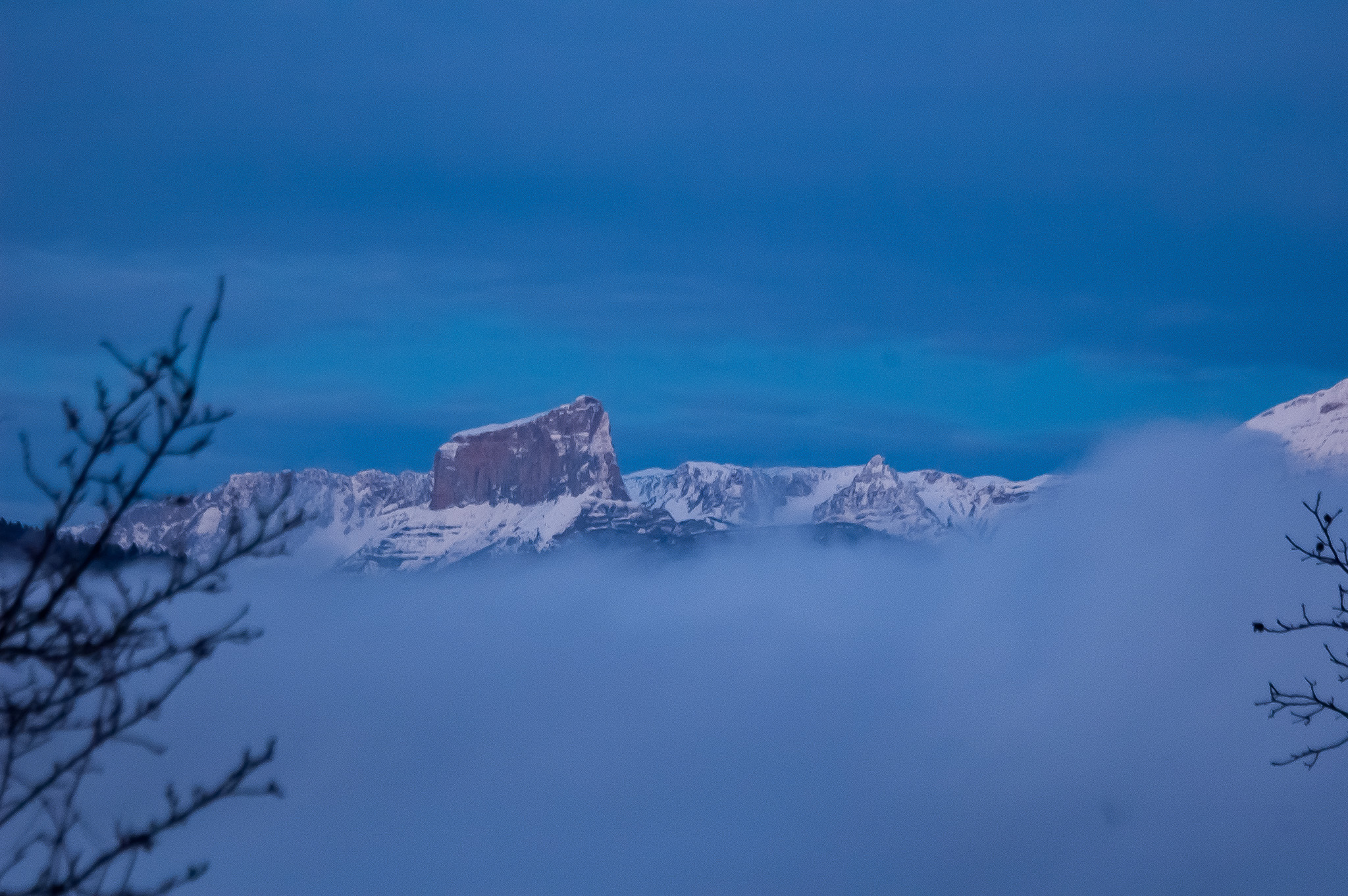 Le Mont Aiguille enneigé immergeant de la mer de nuages